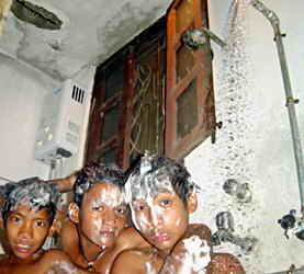 Drei Kinder unter der neuen Dusche.
