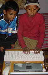 Zwei Kinder vor meinem alten Notebook mit der neuen englisch-nepalischen Tastatur.