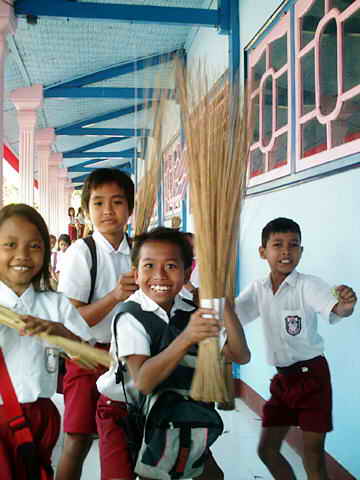 Schulkinder mit Reisgbesen.