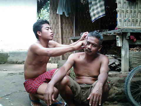 Junger Mann schneidet seinem Vater die Haare.