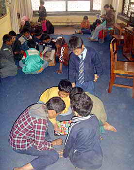 Vier Gruppen spielender Kinder im acht Meter langen Zimmer.