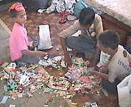 Drei Kinder räumen die Spielzueg-Kiste auf